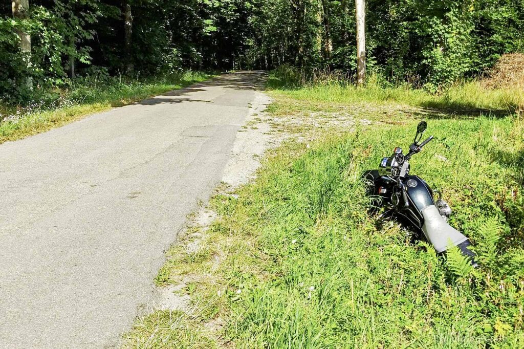 Motorrad steht im Straßengraben etwas tiefer