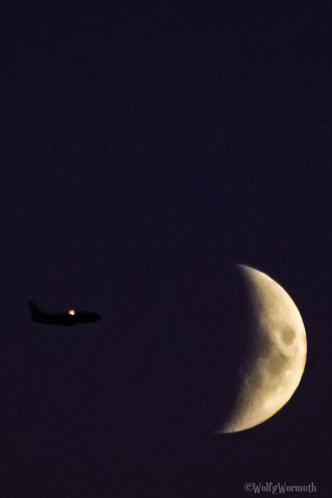 Flugzeug fliegt in der Nacht auf den Mond zu