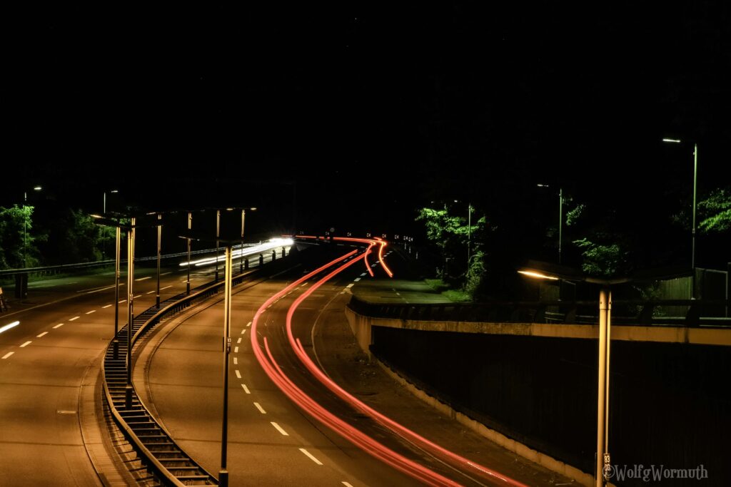 Autobahn A111 bei Nacht. Langzeitaufnahme. Autolichter lange Streifen.