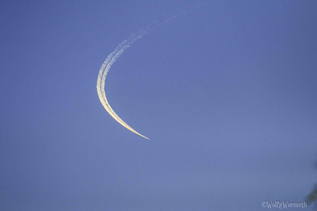 Flugzeug am Himmel mit Kondensstreifen. Fliegt wieder zurück.