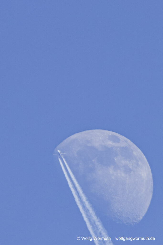 Flugzeug fliegt am Tag auf der Schattenseite vom Mond.