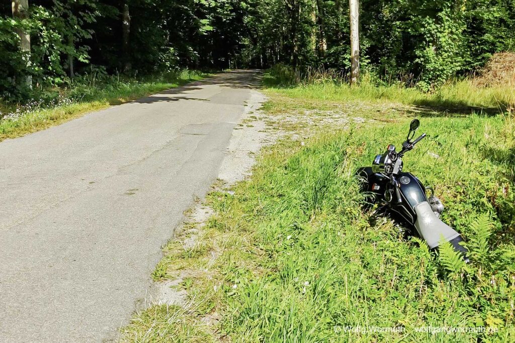 Motorrad steht im Seitengraben einer kleine Straße und kein Besitzer oder Fahrer ist in Sicht.